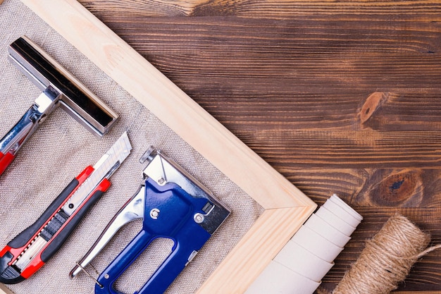 Uno strumento per allungare una tela con una foto su una barella di legno Cucitrice per pinza per graffette e coltello per cancelleria