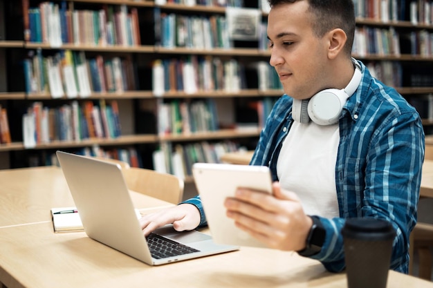 Uno studente al college sta leggendo un ebook nelle mani di un laptop per navigare in Internet