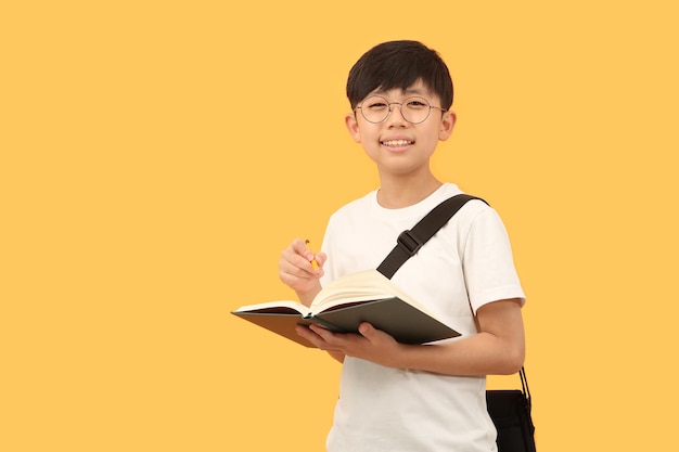 Uno studente con uno zaino e un libro sorride felice con un'espressione luminosa.
