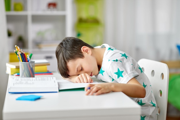 uno studente stanco che dorme sul tavolo a casa