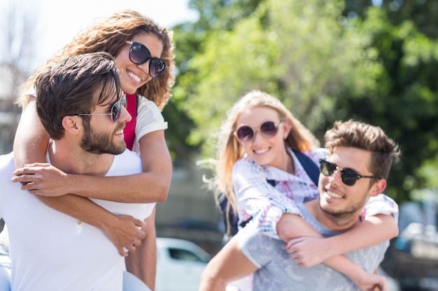 Uomini alla moda che fanno le spalle alle loro amiche per strada