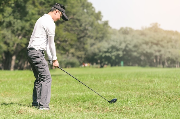 Uomini asiatici che giocano a golf. gli uomini giocano a golf stando in piedi sul campo