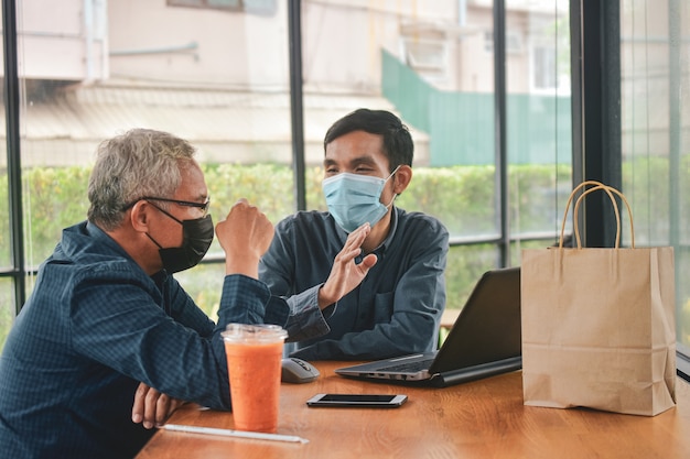 Uomini asiatici con maschera alla riunione