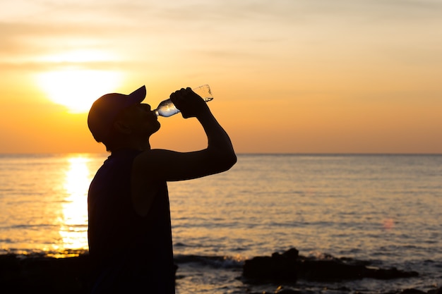 Uomini che bevono acqua dopo l&#39;esercizio