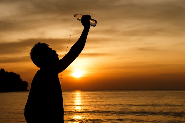 Uomini che bevono acqua dopo l&#39;esercizio