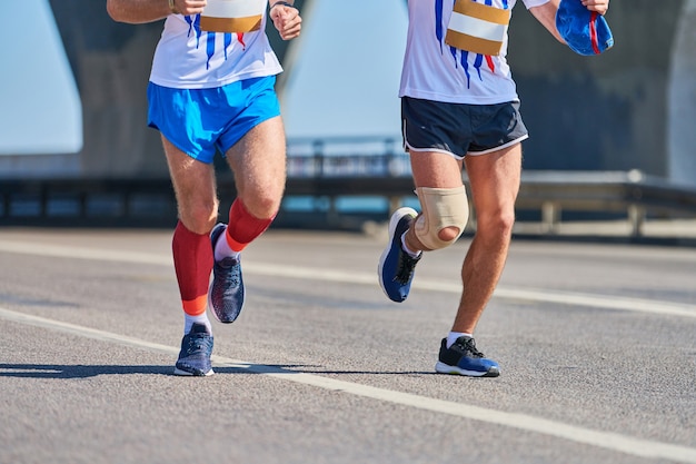 Uomini che corrono. Uomini di sport che fanno jogging in abiti sportivi sulla strada della città