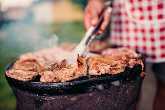 Uomini che indossano grembiule da carne di pollo alla brace