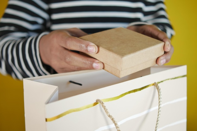 Uomini che prendono una confezione regalo da una borsa della spesa