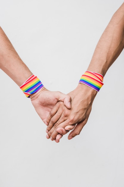 Uomini che si tengono per mano con nastri in colori LGBT