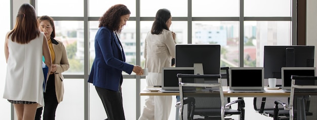 Uomini d'affari che camminano in un ufficio moderno in orario di lavoro con fretta, occupato e fretta.