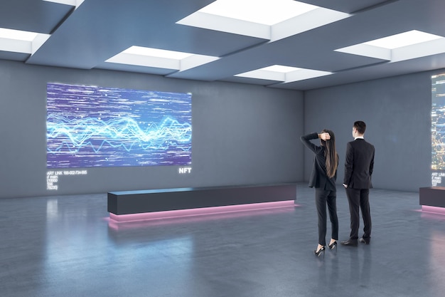 Uomini d'affari che guardano l'immagine digitale moderna sul muro grigio in un elegante loft interior design mostra galleria d'arte che investe e concetto NFT