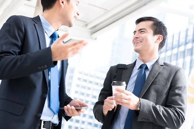 Uomini d&#39;affari che parlano mentre si cammina per lavorare al mattino