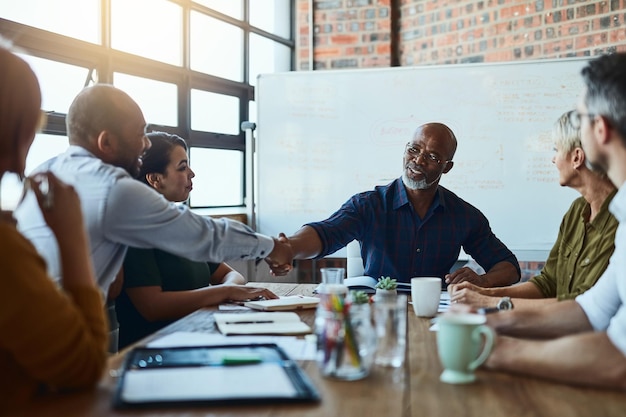 Uomini d'affari che si incontrano e si stringono la mano con l'amministratore delegato per una partnership commerciale o una collaborazione senior Sorridi stringendo la mano o uomini di colore con congratulazioni d'accordo o negoziazione di gruppo b2b o grazie