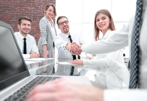 Uomini d'affari che si stringono la mano al tavolo dell'ufficio