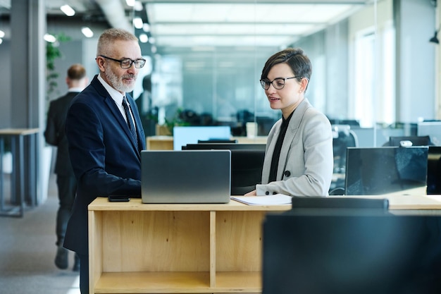 Uomini d'affari che utilizzano laptop al lavoro