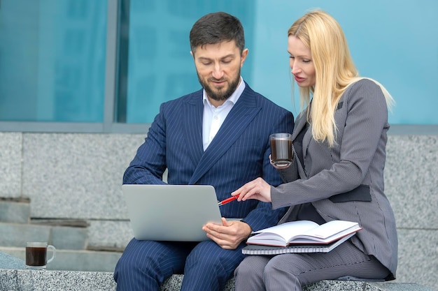 uomini d'affari di successo uomo e donna con documenti e laptop in mano discutono di progetti aziendali