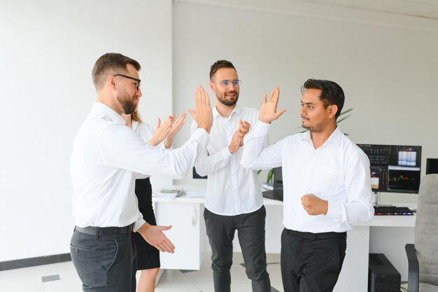 Uomini d'affari felici che ridono mentre collaborano a un nuovo progetto in un ufficio Gruppo di uomini d'affari diversi che lavorano insieme in uno spazio di lavoro moderno