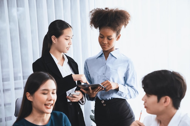 Uomini d'affari felici e diversi lavorano insieme discutendo in un ufficio aziendale Lavoro di squadra professionale e diversificato discutono il piano aziendale sulla scrivania con il computer portatile Impiegato multiculturale moderno Concord