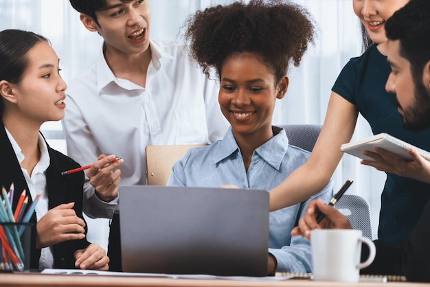 Uomini d'affari felici e diversi lavorano insieme discutendo in un ufficio aziendale Lavoro di squadra professionale e diversificato discutono il piano aziendale sulla scrivania con il computer portatile Impiegato multiculturale moderno Concord