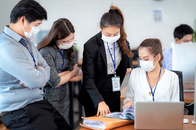 Uomini d'affari fiduciosi con maschera facciale proteggono dal Coronavirus o COVID-19. Concetto di aiuto, supporto e collaborazione insieme per superare l'epidemia di Coronavirus o COVID-19 per riaprire l'attività.