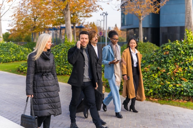 Uomini d'affari multietnici business park colleghi che camminano per andare al lavoro