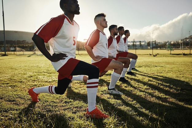Uomini di calcio fitness e stretching con la squadra sportiva durante l'allenamento o l'allenamento sul campo sportivo Gruppo di atleti o lavoro di squadra nella diversità lavoro di squadra e collaborazione sul riscaldamento per la partita di calcio