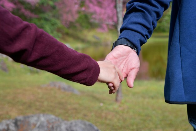 Uomini e donne che camminano mano nella mano con la felicità con l'amore