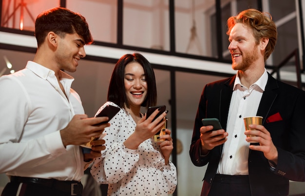 Uomini e donne che controllano i loro telefoni alla festa di capodanno