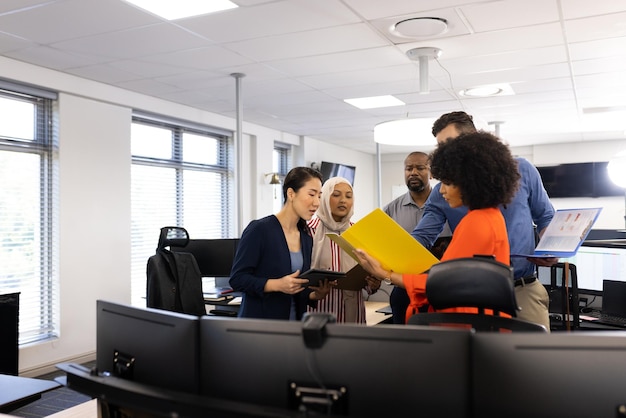 Uomini e donne d'affari felici e diversi che parlano e lavorano in ufficio.