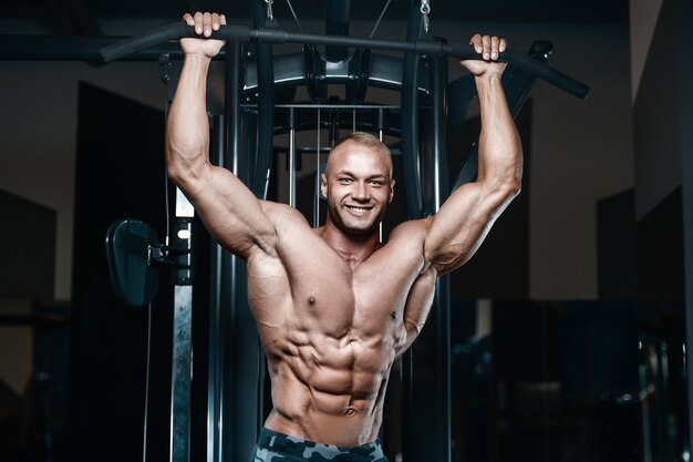 Uomini fitness facendo esercizi di pull-up in palestra