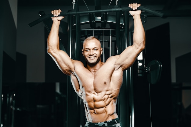 Uomini fitness facendo esercizi di pull-up in palestra