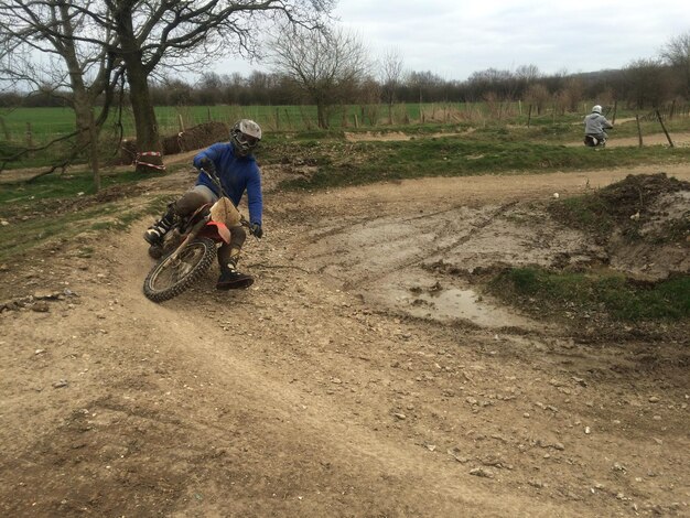 Uomini in moto sul campo contro il cielo