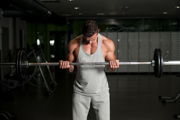 Uomini In Palestra Che Esercitano I Bicipiti Con Il Bilanciere