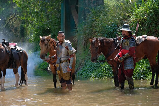 Uomini in piedi con il cavallo nel fiume