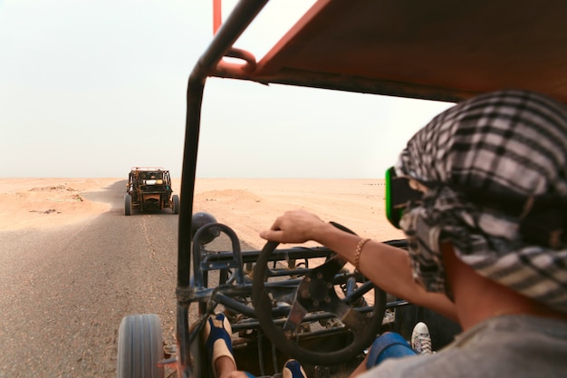 Uomini in sella a una carrozzina nel deserto