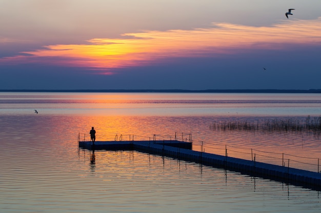 Uomini sul molo del pontone al tramonto