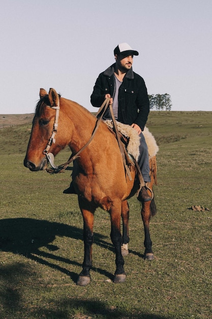 Uomo a cavallo su terra contro un cielo limpido