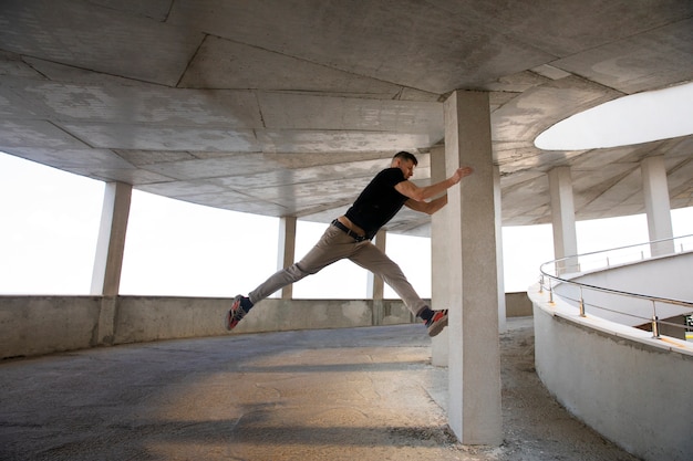 Uomo a figura intera che fa addestramento al parkour