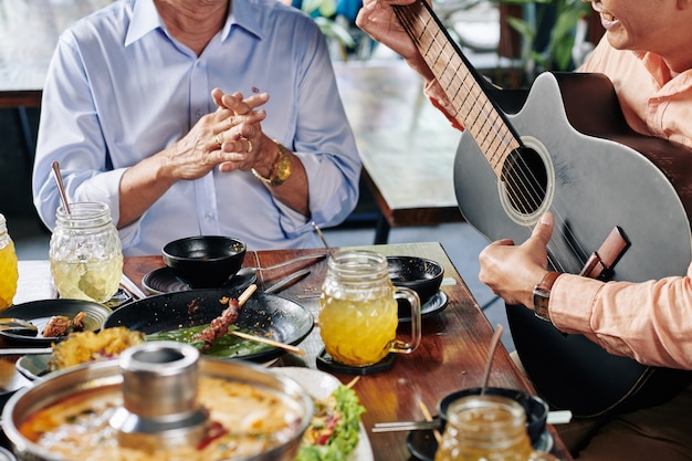 Uomo a suonare la chitarra a cena