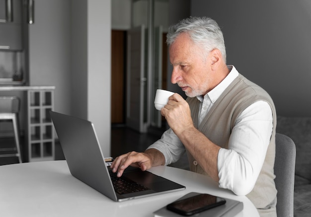 Uomo a tiro medio con laptop e tazza