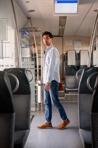 Uomo a tutto campo che viaggia in treno