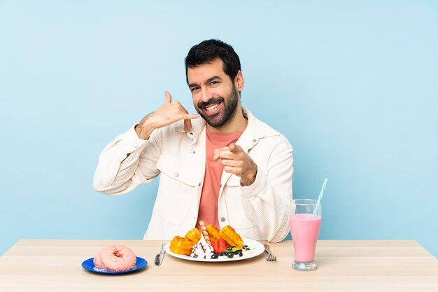 Uomo a un tavolo con cialde per la colazione