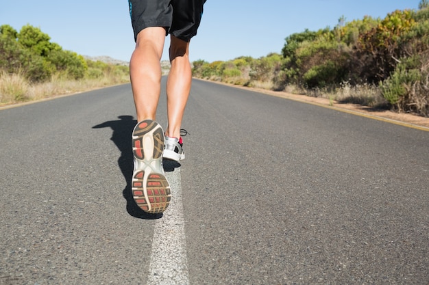 Uomo adatto che pareggia sulla strada aperta