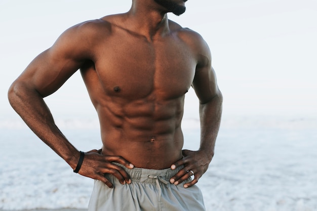 Uomo adatto che propone in spiaggia