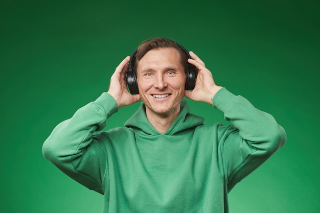 Uomo adulto che ascolta la musica in verde