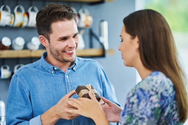 uomo adulto che fa un regalo a sua moglie in cucina