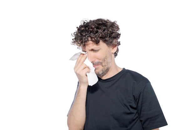 Uomo adulto di mezza età che si asciuga le lacrime con un fazzoletto su uno sfondo bianco