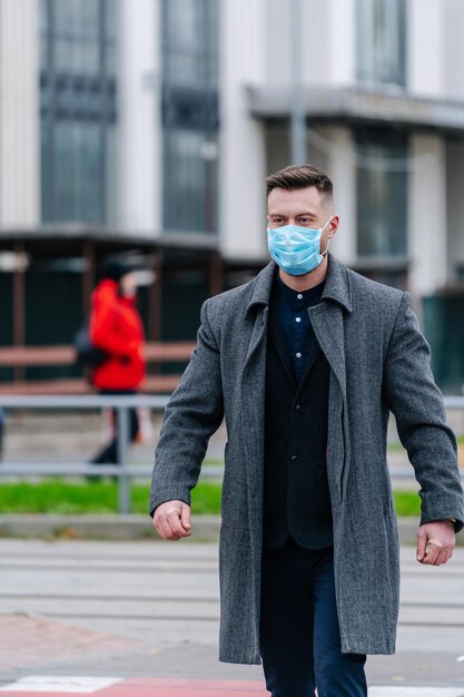 Uomo adulto in maschera che cammina all'aperto. Quarantena per pandemia covid.