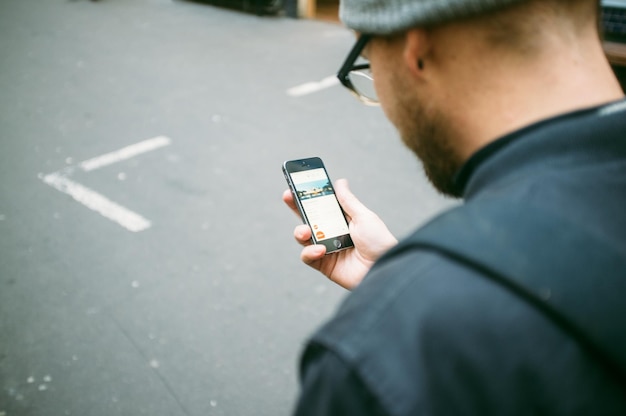 Uomo adulto medio che usa il telefono in strada