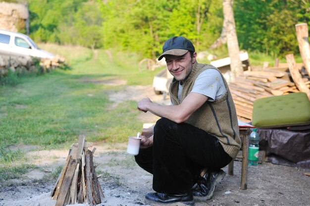 uomo adulto rilassato beve caffè fresco sul fuoco